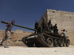 Syrští povstalci s tankem nedaleko Aleppa na severu Sýrie.