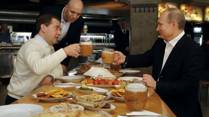Dmitrij Medveděv a Vladimir Putin si pochutnávají na ruských specialitách.