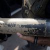 An Israeli police explosives expert holds the remains of a rocket in Kibbutz Nirim