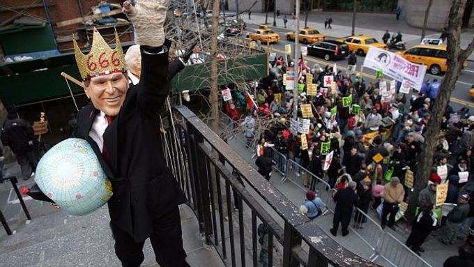 Muž v masce prezidenta USA George Bushe pokřikuje na ostatní protestanty během demonstrace v New Yorku.