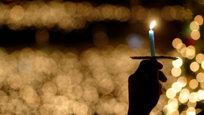 Křesťan drží svíčku v Surabaje, na východu Jávy. Více než 17 000 policistů hlídalo kostely v indonéském hlavním městě Jakartě, aby se neopakovaly útoky na církevní budovy, ke kterým došlo na Štědrý den před sedmi lety.