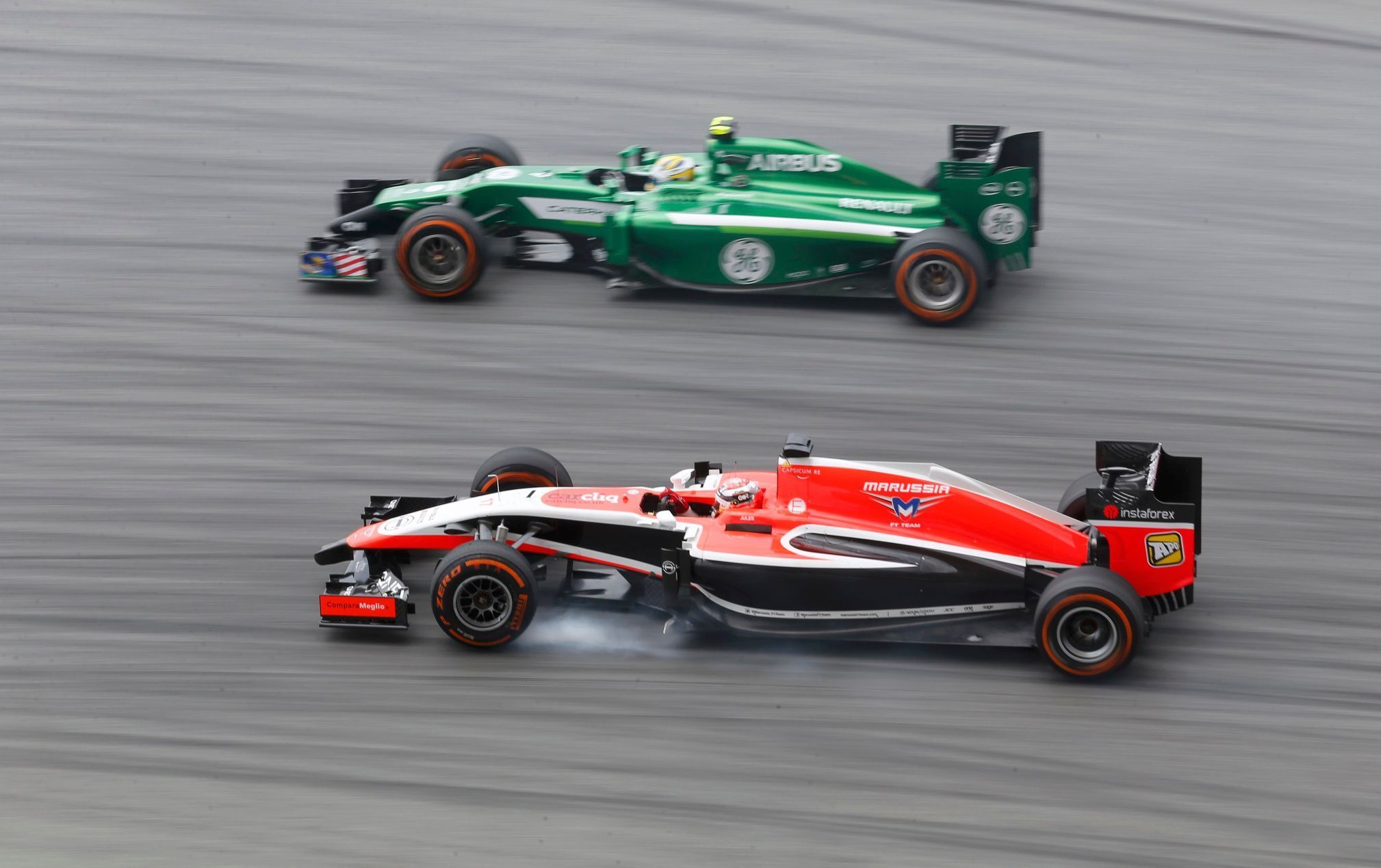Marussia Formula One driver Bianchi passes Caterham Formula One driver Ericsson during the first practice session of the Malaysian F1 Grand Prix at Sepang International Circuit outside Kuala Lumpur