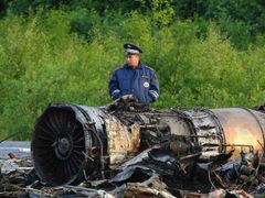 Policista hlídkuje u trosek spadlého stroje; k letišti v Petrozavodsku zbývá ještě kilometr.