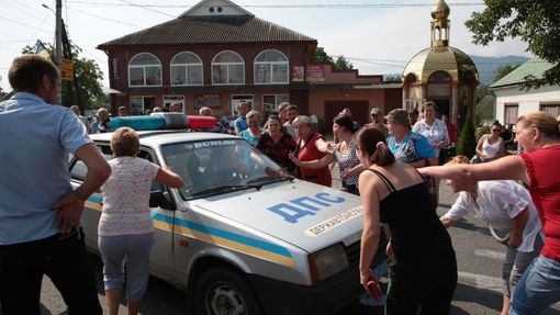 Protestující blokují v obci Bedevlja policejní auto.