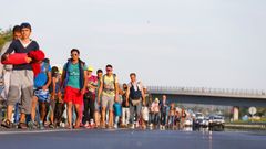 Migrants march along the highway towards the border with Austria