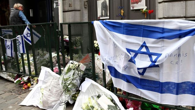 Květiny a izraelské vlajky na místě činu. Před Židovským muzeem v Bruselu.