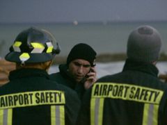 Záchranáři na pobřeží poblíž místa, kde se letadlo zřítilo.