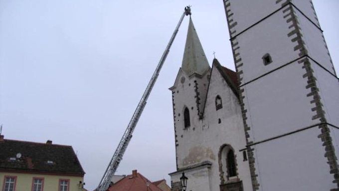 Hasiči museli vztyčit žebřík do výšky 53 metrů a odříznout kříž z píseckého kostela. Visel jen na několika šroubech.