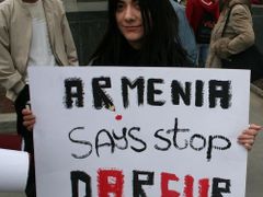 "Arménie říká: Zastavte Dárfur" Mladá Arménka stojí před budovou jerevanské opery a čeká na zahájení pochodu s ohni. Zatímco Arménská genocida byla první v minulém století, vyhlazování civilního obyvatelstva v súdánském Dárfúru je první genocidou tohoto století.