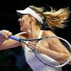 Sharapova of Russia hits a return to Kvitova of the Czech Republic during their WTA Finals singles tennis match at the Singapore Indoor Stadium