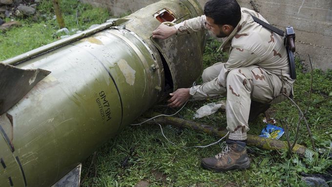 Příslušník povstaleckých jednotek kontroluje vypálenou raketu na jihozápadě Sýrie.