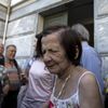 People, most of them pensioners, gather outside a closed National Bank branch at the bank's headquarters in Athens