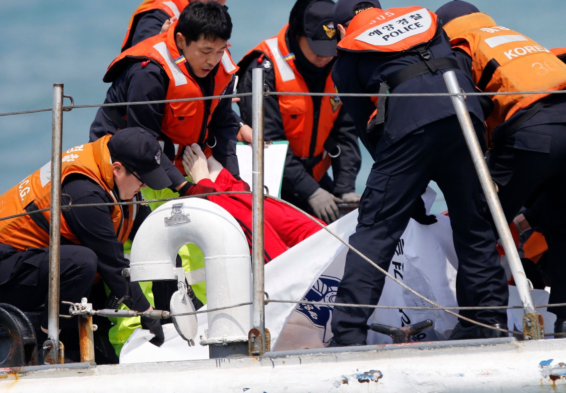 South Korean coastguard officers recover a body on their vessel at the site where the capsized passenger ship Sewol sank in the sea off Jindo