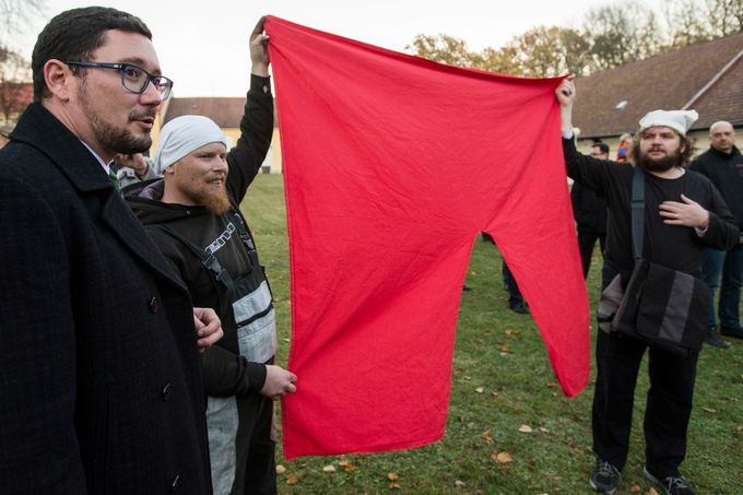 Tiskový mluvčí Jiří Ovčáček přihlíží demonstraci odpůrců Miluše Zemana, kteří drží symbol Červených trenek, jenž do povědomí veřejnosti dostala skupina Ztohoven. 2015