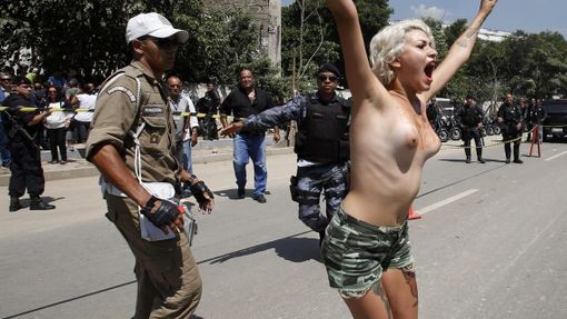 An activist from Femen Brazil protests in support of the native Indian community in front of the Brazilian Indian Museum in Rio de Janeiro, March 22, 2013. Brazilian military police took position early morning outside the abandoned Indian museum, where a native Indian community of around 30 individuals have been living since 2006. The Indians were summoned to leave the museum in 72 hours by court officials since last week, local media reported. The group is fighting against the destruction of the museum, which is next to the Maracana Stadium. REUTERS/Sergio Moraes (BRAZIL - Tags: CIVIL UNREST POLITICS SOCIETY SPORT) TEMPLATE OUT Published: Bře. 22, 2013, 5:25 odp.