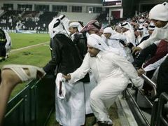 Fotbalové fandovství se šíří po světě: Katarští fotbaloví fanoušci pronikají na hrací plochu po vítězství jejich fotbalistů ve finále Asijských her na Irákem.