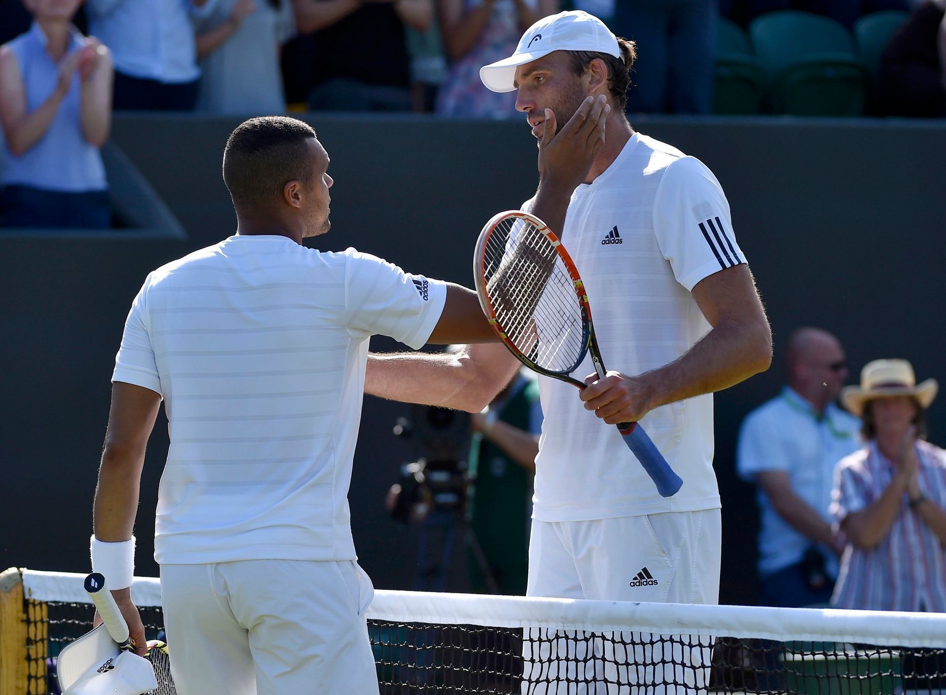 Ivo Karlovic of Croatia meets Jo-Wilfried Tsonga of France at the net after winning their match at the Wimbledon Tennis Championships in London
