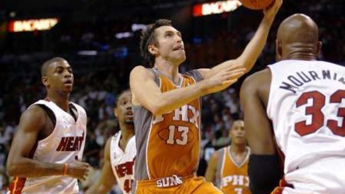 Steve Nash z Phoenixu Suns (uprostřed) zakončuje v zápase basketbalové NBA přes Alonsa Mourninga z Miami Heat.