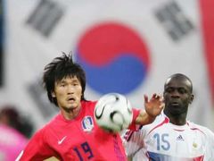 Korejec Cho Jae-jin (vlevo) v souboji o míč s Lilianem Thuramem z Francie.