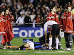 Burdisso z Interu Milán leží na trávníku se zlomeným nosem po zásahu Navarra z Valencie.