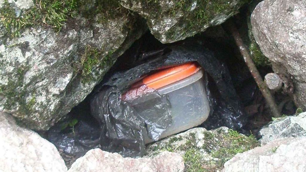Keška ("cache"): schránka s deníkem ("logbook") a drobnými předměty pro výměnu.