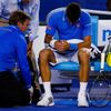 Djokovic of Serbia receives medical attention after he injured his hand while trying to return a shot to Murray of Britain in their men's singles final match at the Australian Open 2015 tennis tournam