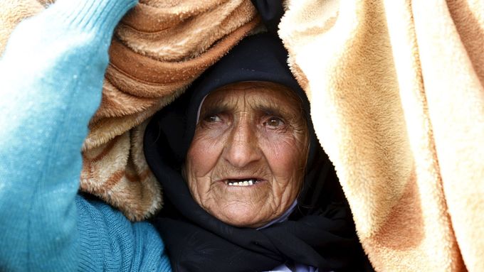 Syrská žena nese svůj majetek k hranici v Tureckem.