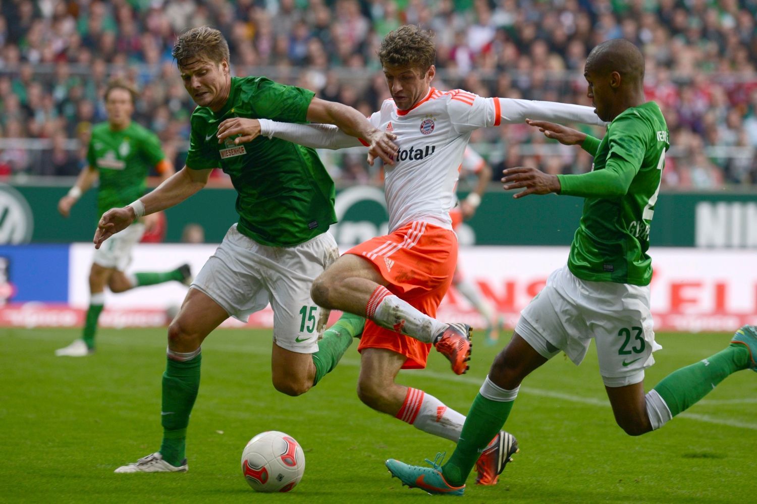 Fotbalisté Theodor Gebre Selassie a Sebastian Prödl z Werderu Brémy se snaží zastavit Thomase Müllera z Bayernu Mnichov.