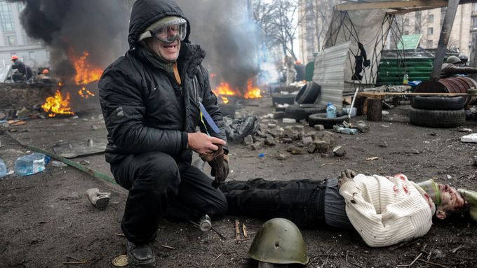 Demonstrant pláče nad jednou z obětí masakru v ukrajinském Kyjevě 20. února 2014.