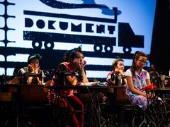 Sál DKO zaplnily šicí stroje a zmechanizovaná lidskost tvořící obraz současné továrny. Dělnice v stejnokrojích a dva bachaři pracující v monotoním rytmu vietnamské hudby.