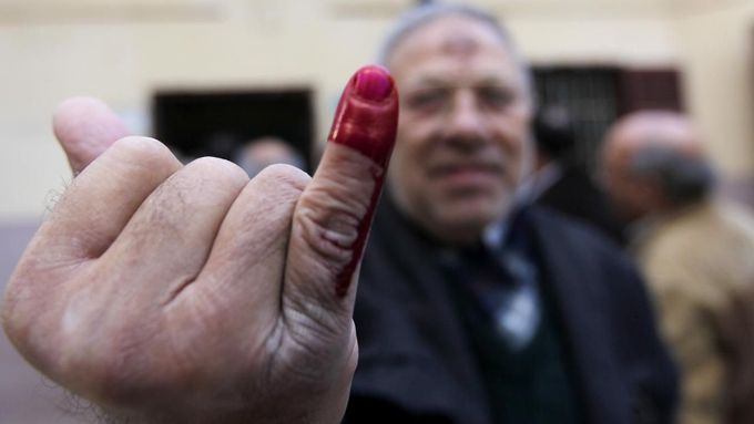 Odhlasováno. Egypťan ukazuje inkoustem označený malíček, jenž je důkazem, že se zúčastnil referenda o nové ústavě.