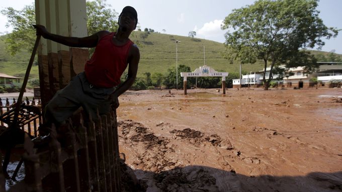 Muž si prohlíží spoušť, kterou zanechalo bahno v jedné z postižených brazilských vesnic.