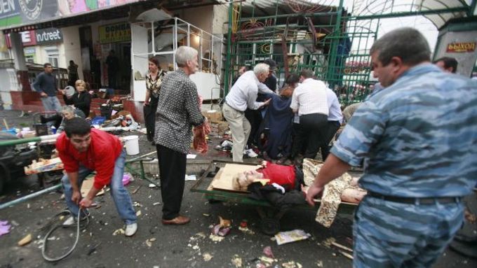 Zraněná žena před vchodem na tržiště ve Vladikavkazu.