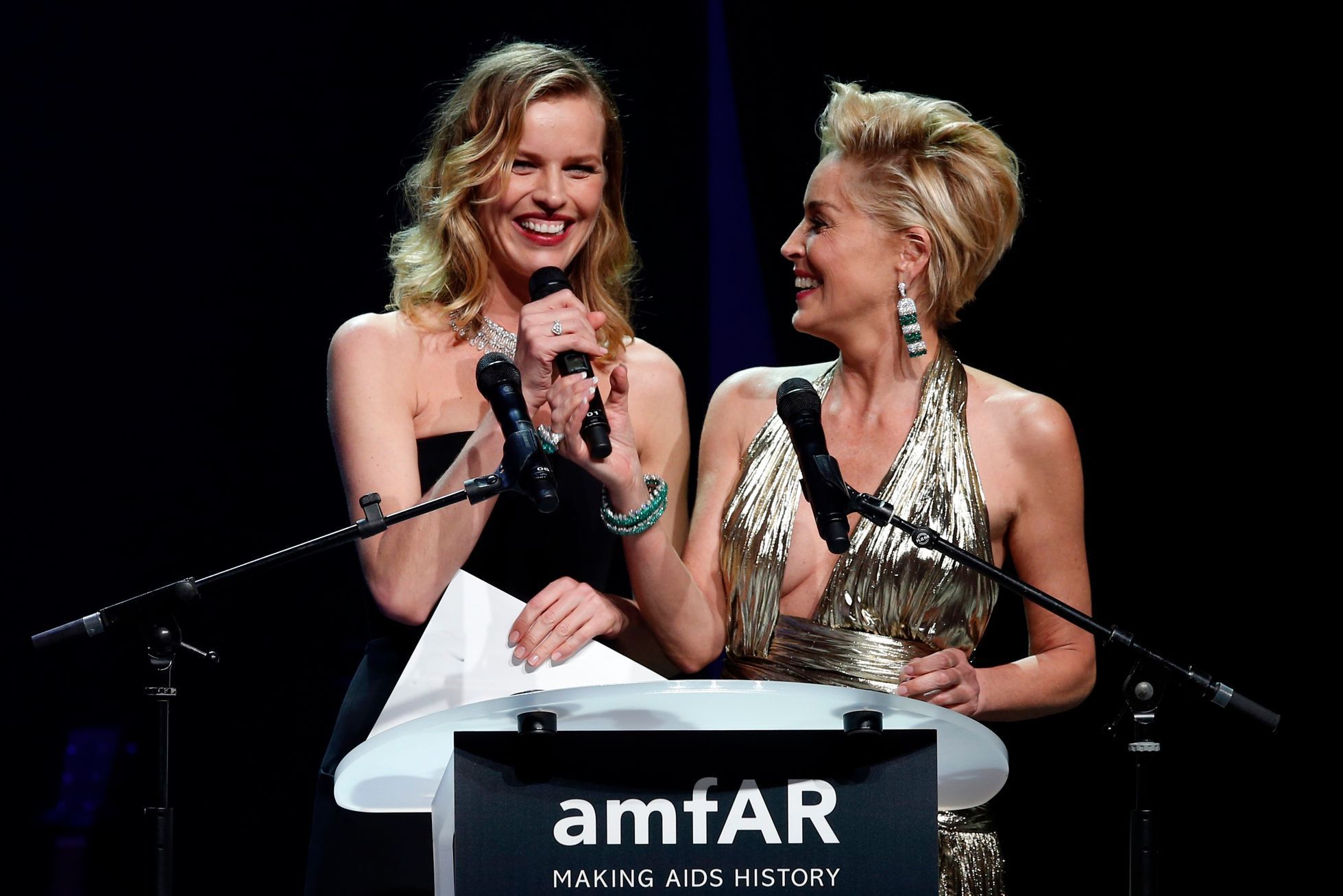 Model Herzigova of the Czech Republic and actress Stone of the U.S. attend an auction at the amfAR's Cinema Against AIDS 2014 event in Antibes
