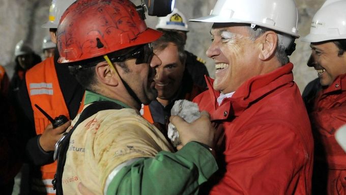 Momentka z vyprošťování zavalených horníků. Na snímku objímá jednoho ze zachráněných - Maria Sepúlvedu - prezident země Piňera.