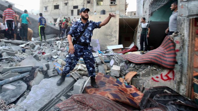 Palestinský policista organizuje civilisty při hledání obětí izraelského raketového útoku. náletu na město Rafáh v jižní části Pásma Gazy.