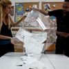 Members of an electoral commision empty a ballot box  after the end of voting at a polling station in Athens