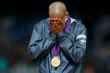 Překážkář Felix Sanchez pláče štěstím se zlatou medailí za 400 metrů překážek.