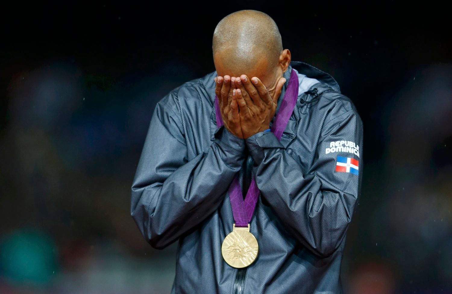 Překážkář Felix Sanchez pláče štěstím se zlatou medailí za 400 metrů překážek na OH 2012 v Londýně.