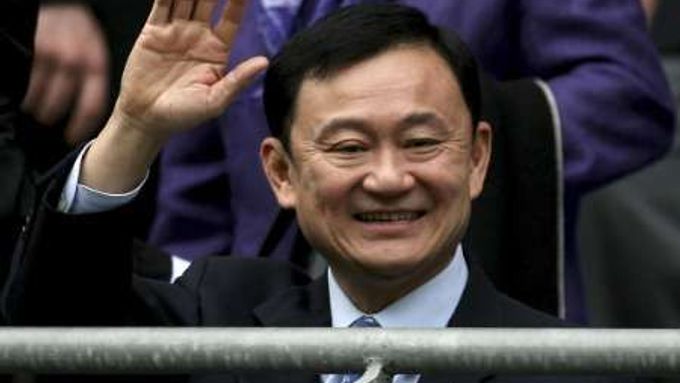 Thaksin zdraví své příznivce v hledišti fotbalového stadiónu klubu Manchester City, který mu patří
