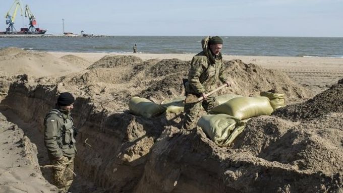 Ukrajinští vojáci v zákopech na pláži u mariupolského přístavu.