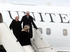 Manželé Clintonovi a Madeleine Albrightová vystupují z letadla.