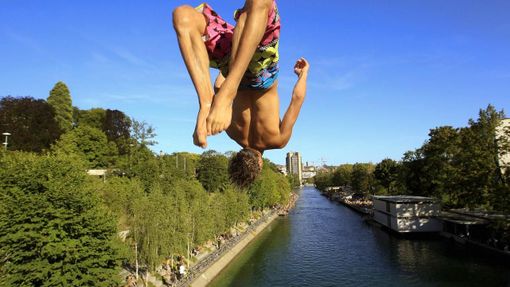 A man jumps from a bridge into the Limmat river during sunny summer weather in Zurich August 17, 2012. The Federal Office of Meteorology MeteoSwiss has launched a warning for a heat wave for the weekend until August 22. REUTERS/Arnd Wiegmann (SWITZERLAND - Tags: ENVIRONMENT SOCIETY TPX IMAGES OF THE DAY) Published: Srp. 17, 2012, 6:13 odp.