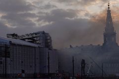 Hasiči likvidují zbytky požáru renesanční burzy v Kodani. Z budovy stále stoupá kouř