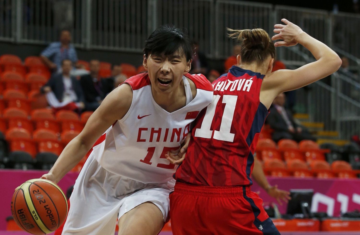 Česká basketbalistka Kateřina Elhotová (zády) se snaží bránit Číňanku Nan Čenovou v turnaji OH 2012 v Londýně.