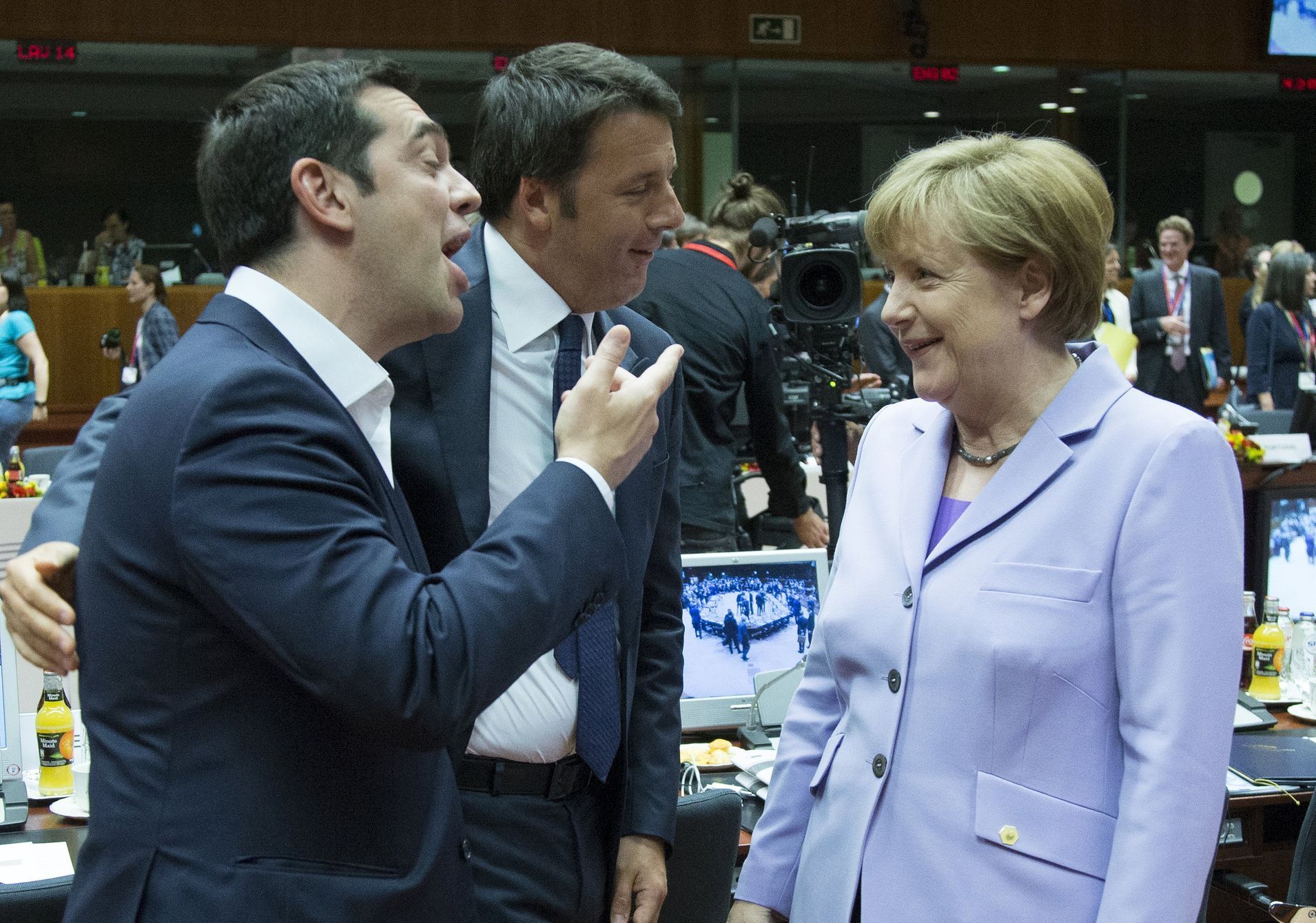 Greek Prime Minister Alexis Tsipras talks to German Chancellor Angela Merkel next to Italian Prime Minister Matteo Renzi at a European Union leaders summit in Brussels