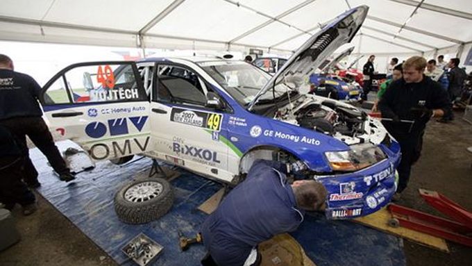 Mechanici pracují na Mitsubishi Štěpána Vojtěcha během Rallye Nový Zéland.