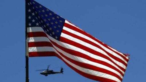 A U.S. Army Apache helicopter flies past a flag on Observation Post Mustang in Afghanistan's Kunar Province June 4, 2012. REUTERS/Tim Wimborne (AFGHANISTAN - Tags: CIVIL