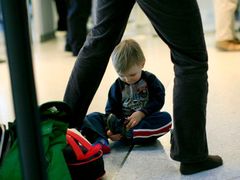 Malý terorista? Chlapec si zouvá boty, čeká ho zevrubná kontrola u bezpečnostního rámu na letišti Newark v New Jersey.