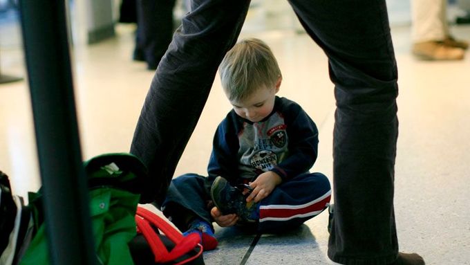 Malý terorista? Chlapec si zouvá boty, čeká ho zevrubná kontrola u bezpečnostního rámu na letišti Newark v New Jersey.